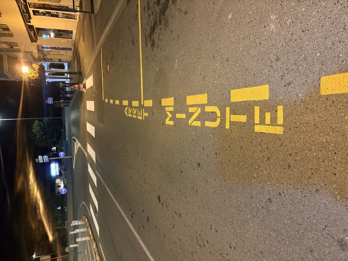 Marquage places de stationnement arrêt minute jaunes et passage piéton blanc sur enrobé de nuit