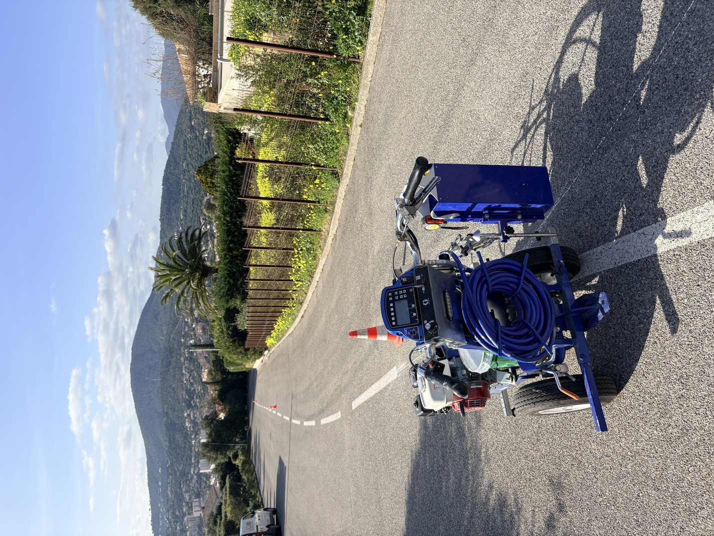 Machine de marquage en action pour la réalisation d'une bande blanche continue sur enrobé de voie résidencielle